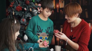Çocuklar oynamaya yakın Noel ağacı ile anne