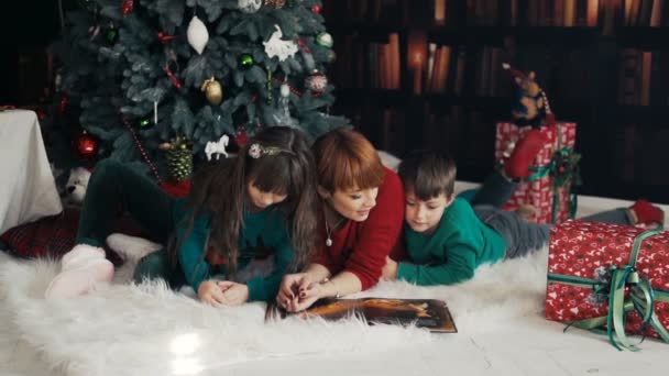 Семейная книга Чтение рядом с елкой — стоковое видео