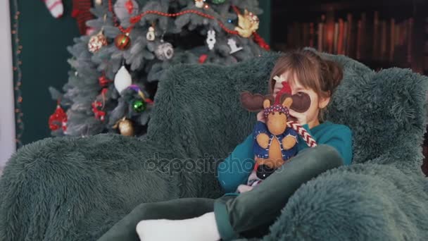 Fille dans le fauteuil avant arbre de Noël — Video