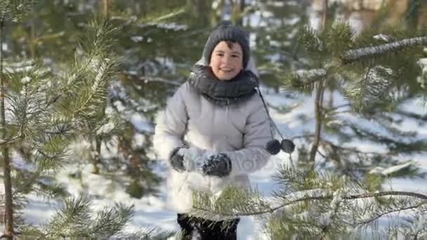 Молодая девушка развлекается со снежками в парке — стоковое видео