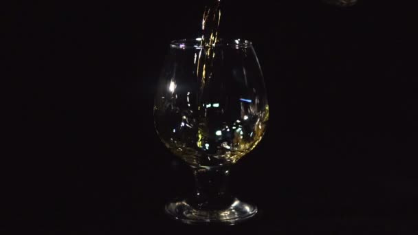Whiskey hälla i glas på svart — Stockvideo