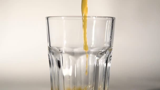Suco de laranja derramando em vidro — Vídeo de Stock