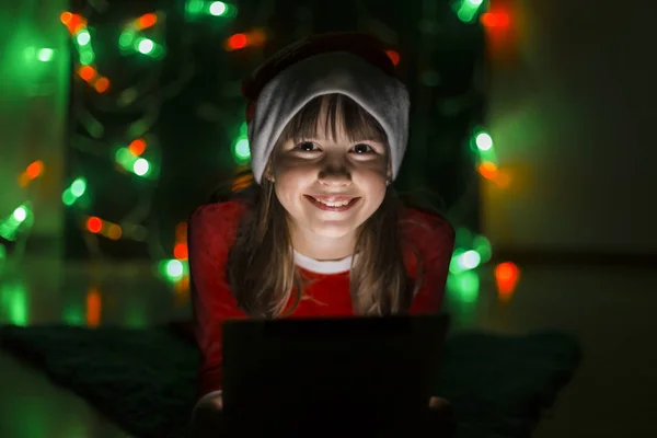 Niña sosteniendo la tableta PC en Santas Sombrero — Foto de Stock