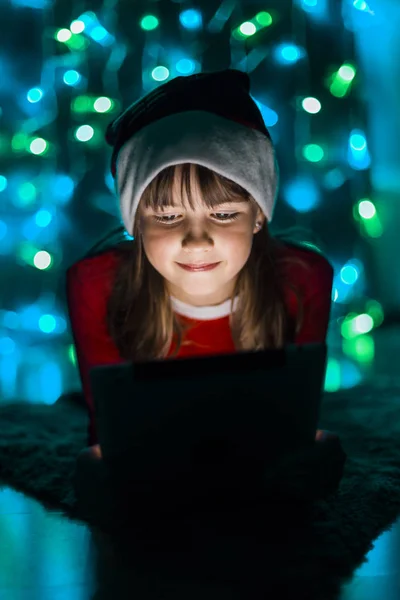 Niña sosteniendo la tableta PC en Santas Sombrero — Foto de Stock