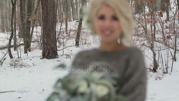 Belle fille blonde tenant un bouquet dans la forêt d'hiver — Video