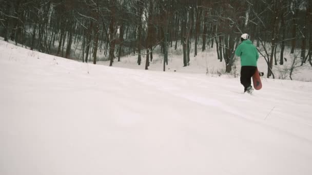 Snowboardåkare promenader snö lutning — Stockvideo