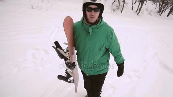 Snowboarder wandelingen sneeuw helling — Stockvideo