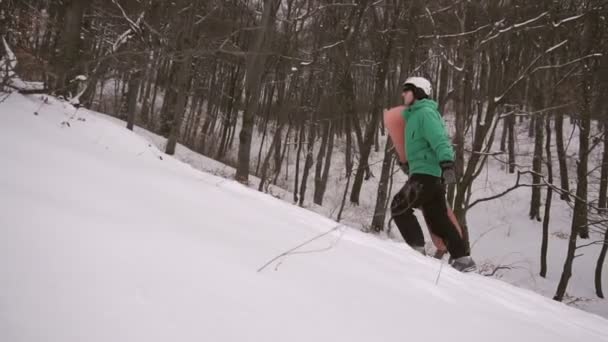 Snowboardista chodí zasněžovaných svahu — Stock video