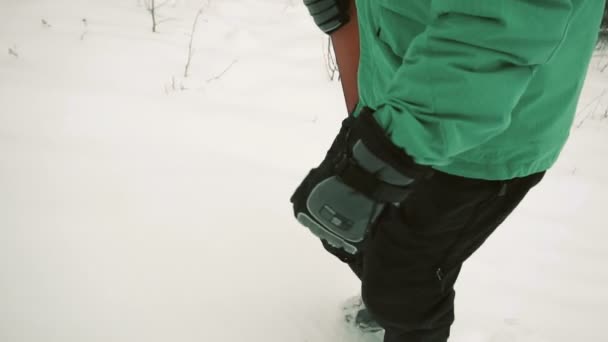 Сноубордист ходит по снежному склону — стоковое видео