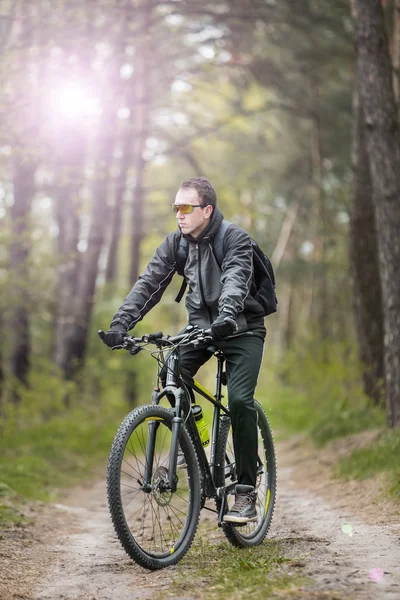 Homem monta uma bicicleta na floresta — Fotografia de Stock