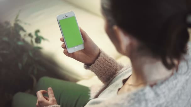 Woman Use Smartphone Sitting on White Sofa — Stock Video