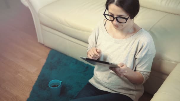 Donna uso Tablet PC seduta vicino divano — Video Stock