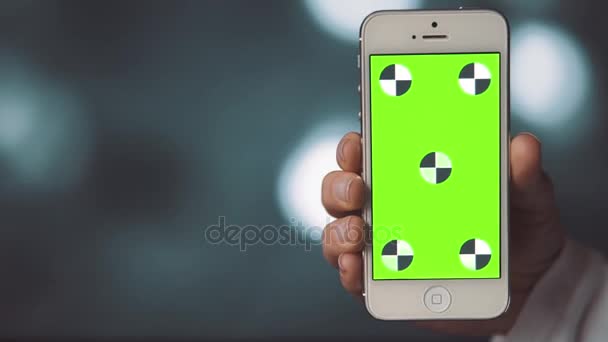 Smartphone con pantalla verde encendido antes de fondo Bokeh — Vídeo de stock