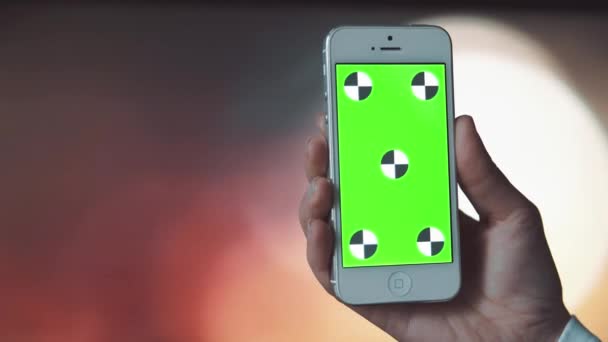 Смартфон с зеленым экраном на фоне Bokeh — стоковое видео