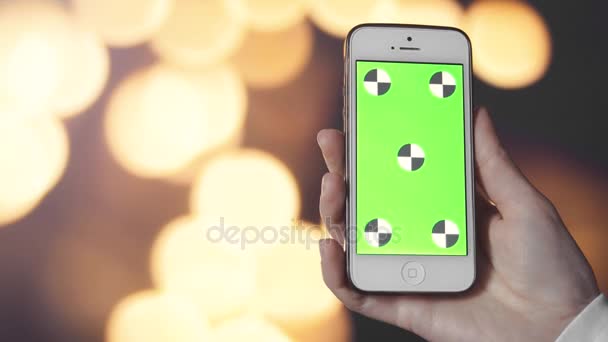 Smartphone con pantalla verde encendido antes de fondo Bokeh — Vídeo de stock