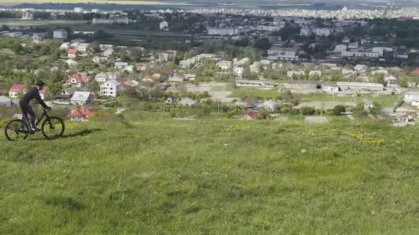 Man rijdt fiets op de top van stad — Stockvideo