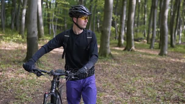 Biker wandert mit Fahrrad durch Wald — Stockvideo
