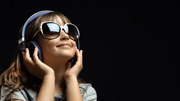 Schattig meisje met hoofdtelefoons en zonnebril — Stockfoto