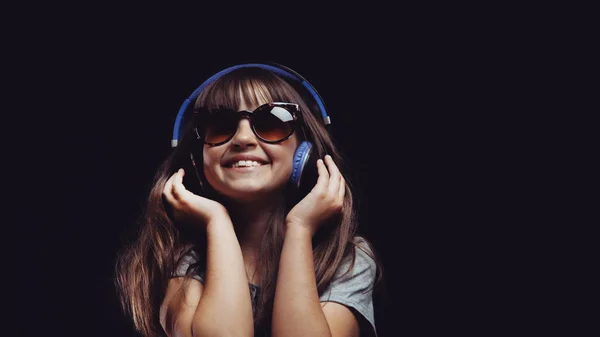 Joven linda chica con auriculares y gafas de sol — Foto de Stock