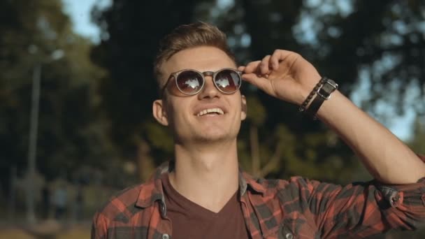 Hombre parque retrato sonrisa gafas de sol — Vídeo de stock