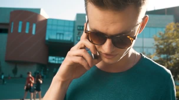 Молодий чоловік говорить по телефону — стокове відео