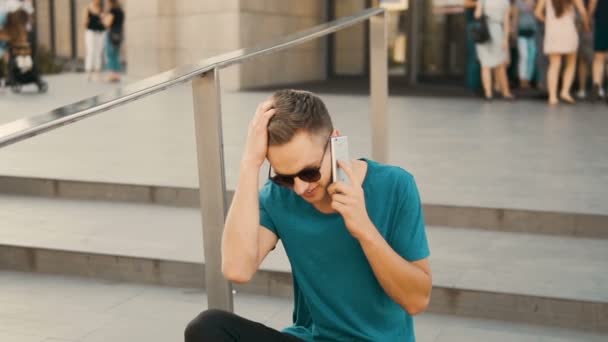 Hombre sentado en las escaleras y hablando por teléfono — Vídeos de Stock