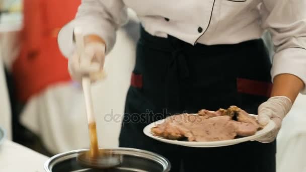 Chef versant de la sauce noire sur de la viande d'agneau cuite au four — Video