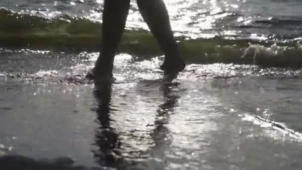 Человек ходит по морской воде — стоковое видео