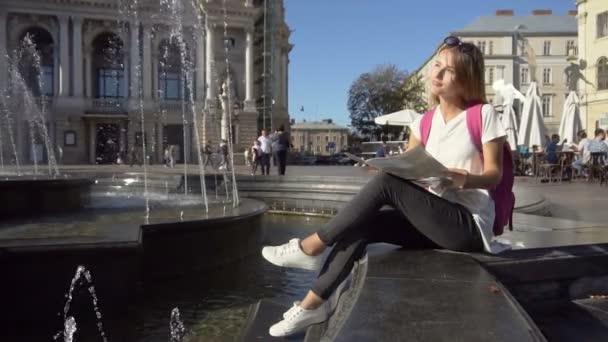 Turysta dziewczyna oglądając mapę w fontannie — Wideo stockowe