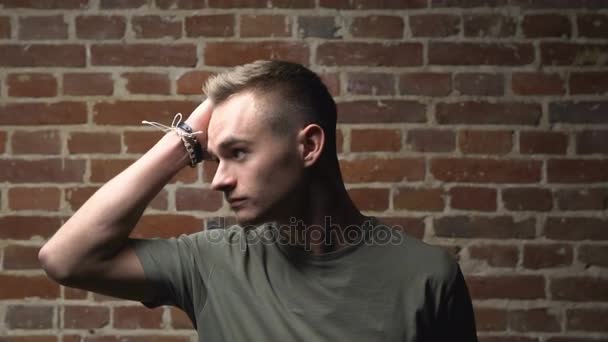 Молодой человек трогает волосы — стоковое видео