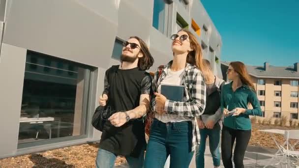 Studenten lopen langs universiteitsgebouw — Stockvideo