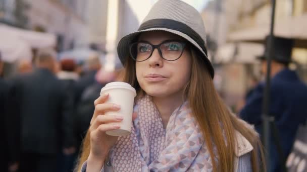 Улыбающаяся девушка пьет кофе — стоковое видео