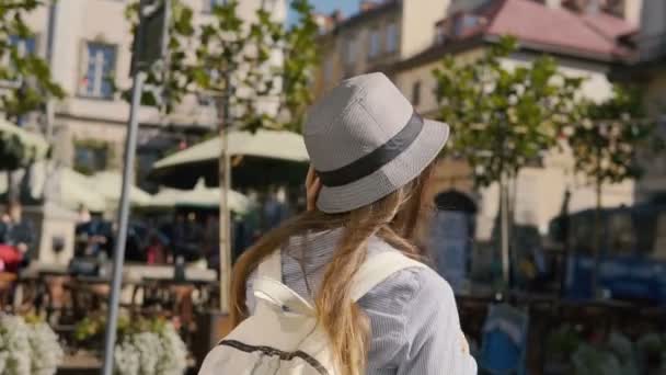 Lächelndes Touristenmädchen spaziert durch die Innenstadt — Stockvideo