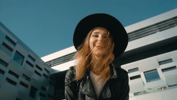 Chica sonriente posa ante edificio moderno — Vídeo de stock