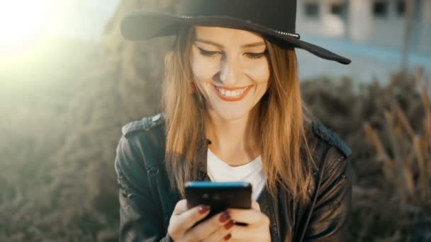 Fröhliches Mädchen, das draußen SMS schreibt — Stockvideo