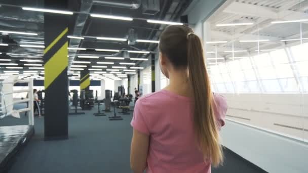 Menina entra no ginásio — Vídeo de Stock