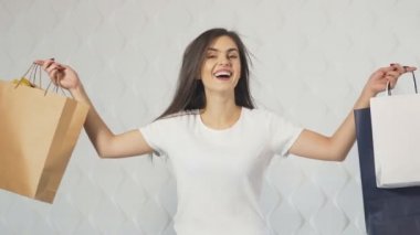 Mutlu kız alışveriş torbaları gösterir