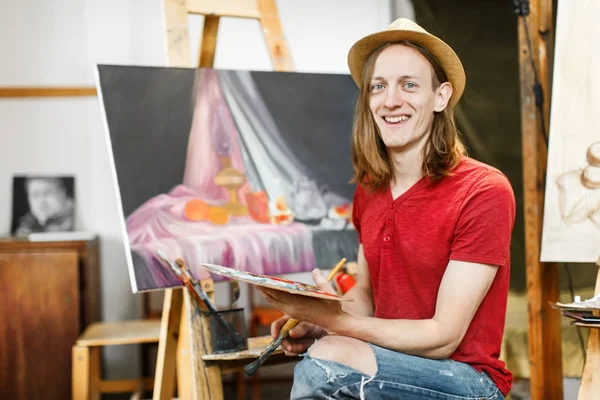 Lachende kunstenaar tijdens schilderij — Stockfoto