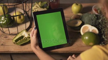 Kadın kullanır Tablet mutfak masasında