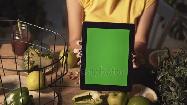 Kadın Tablet mutfak masasında gösterir. — Stok video