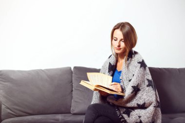 Girl with Book on Sofa clipart