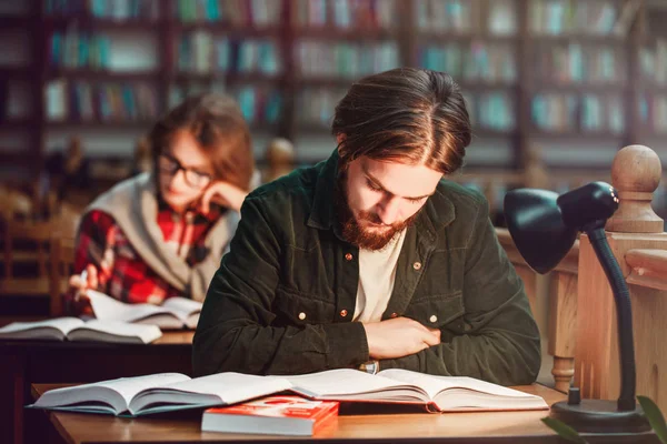 Retrato de pareja de estudiantes en la biblioteca —  Fotos de Stock