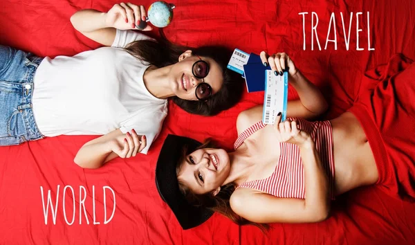 İki kız arkadaş kırmızı yatakta yatarken — Stok fotoğraf