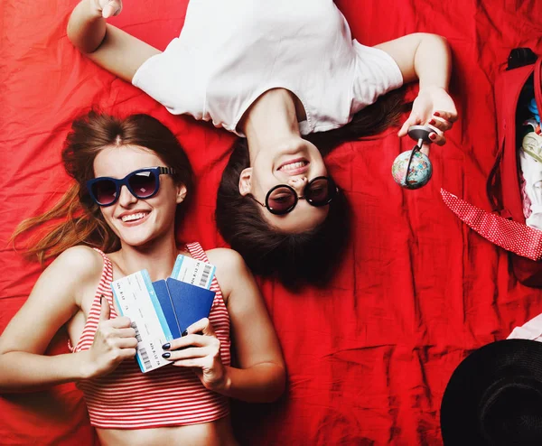 Duas meninas amigas deitadas na cama vermelha — Fotografia de Stock