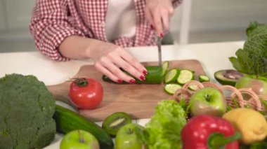 Kız kesim salatalık doğrama kurulu üzerinde