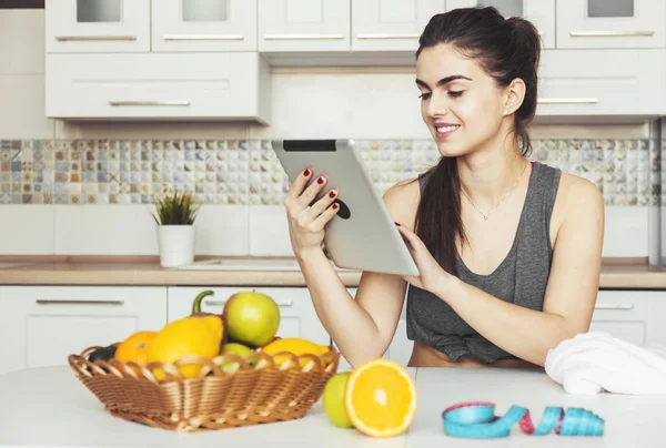 Femme utilise tablette dans la cuisine — Photo