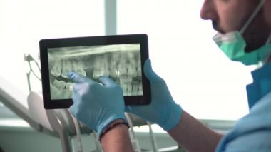 Diş hekimi X-ray Tablet üzerinde gösterir.
