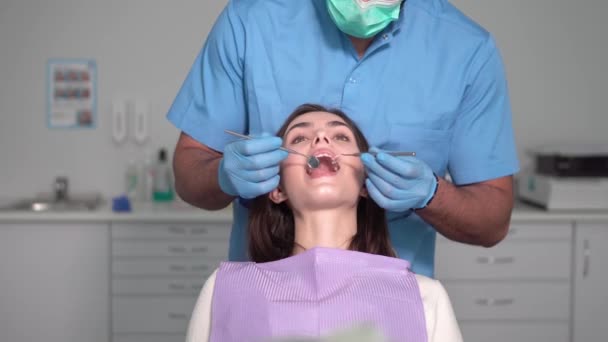 Zubní lékař zkoumá pacientů zuby