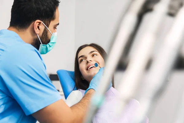 Стоматолог розмовляє з пацієнтом під час перевірки — стокове фото