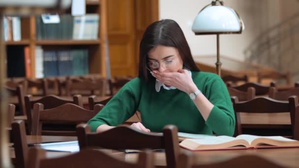 Trött kvinna i biblioteket — Stockvideo